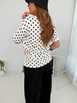 T-Shirt in Weiss mit schwarzen Pünktchen und Print in Rosa vorne.