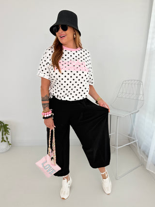 T-Shirt in Weiss mit schwarzen Pünktchen und Print in Rosa vorne.